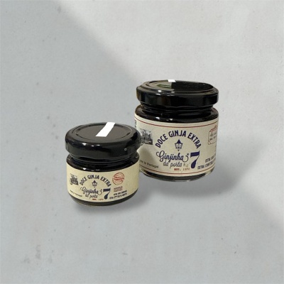 Dois frascos pequenos de vidro com tampa preta e rótulos creme com texto azul escuro de doce de ginja.