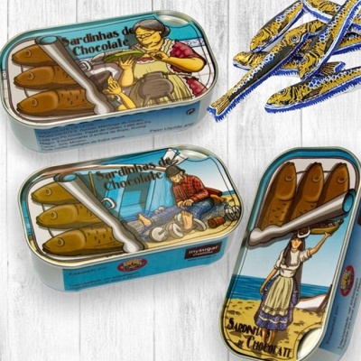 Latas azuis com sardinhas de chocolate ilustradas e sardinhas de chocolate embaladas individualmente