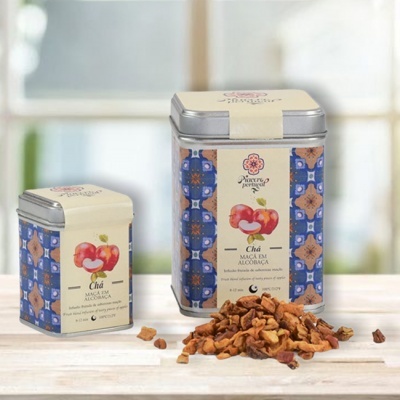 Dois frascos metálicos de chá com rótulo de maçãs e chá solto ao lado