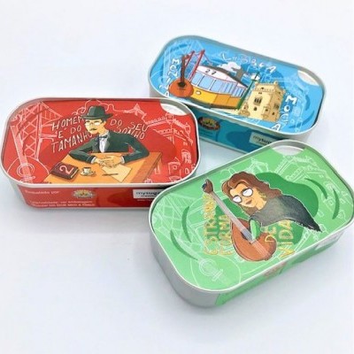 Três latas metálicas com ilustrações coloridas e texto em português