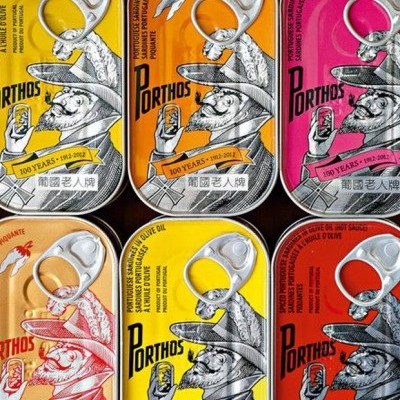 Latas coloridas Porthos com ilustração vintage e texto em português e chinês
