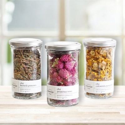 Três frascos de vidro com chá de ervas etiquetados