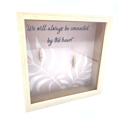 Quadro decorativo com texto e dois prendedores pequenos.