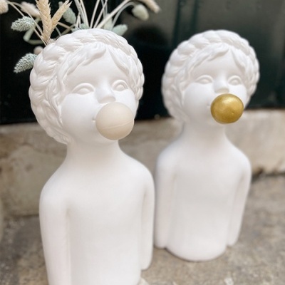 Duas esculturas brancas de bustos de crianças com bolhas de chiclete