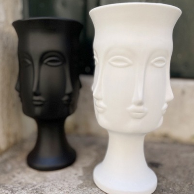 Vasos decorativos em cerâmica com design de rosto estilizado, um branco e um preto