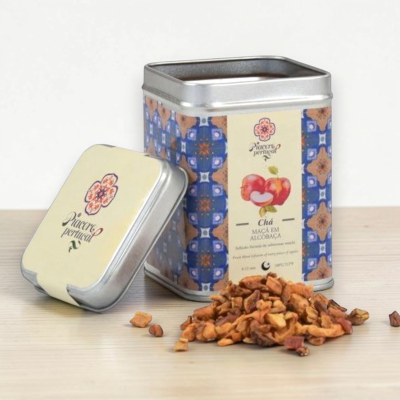 Lata metálica de chá com padrão azul e pedaços de chá seco