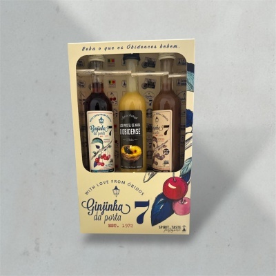 Conjunto de três garrafas de licor em caixa com ilustração de cerejas e texto em português