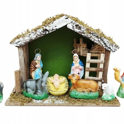 Figuras de presépio coloridas num estábulo de madeira com cobertura de musgo artificial