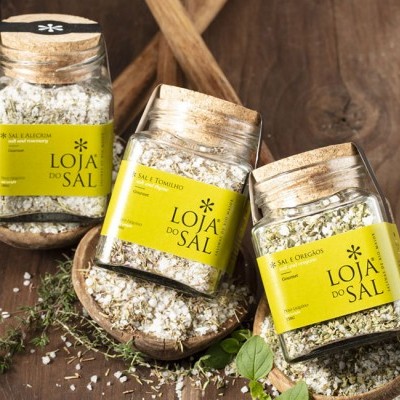 Frascos de sal temperado Loja do Sal com rótulos amarelos e tampas de cortiça em colheres de madeira