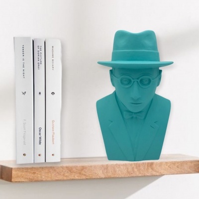 Estante de madeira com livros brancos e busto azul turquesa decorativo