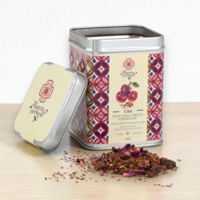 Caixa metálica de chá de cerejas com tampa e chá solto à frente