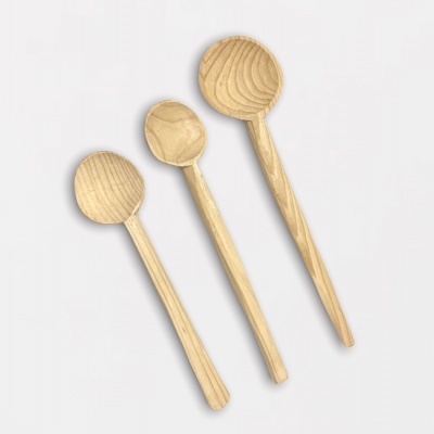 Três colheres de madeira clara sobre fundo branco