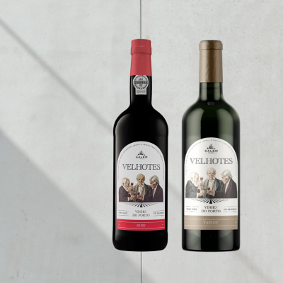 Duas garrafas de vinho do Porto Calem Velhotes, uma vermelha e outra castanha, com rótulos brancos e ilustração de três homens.
