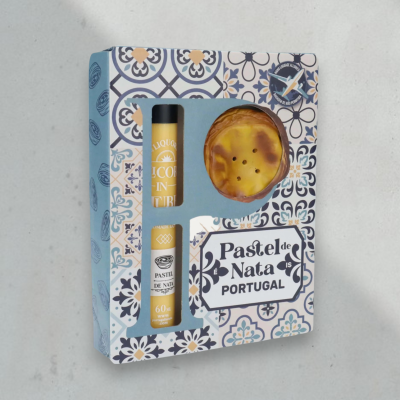 Caixa decorativa azul com frasco de licor amarelo e pastel de nata visível