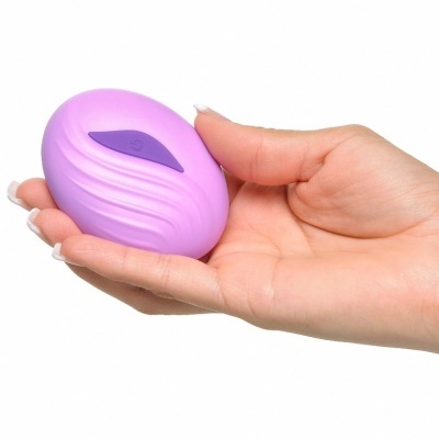 Dispositivo lilás oval com textura ondulada nas mãos femininas