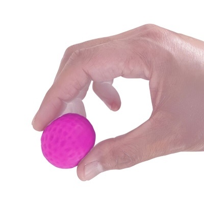 Mão segurando pequena bola rosa texturizada