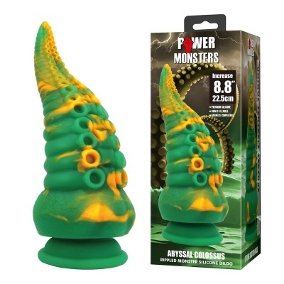 Dildo em forma de tentáculo verde e amarelo com ventosa e embalagem ao fundo
