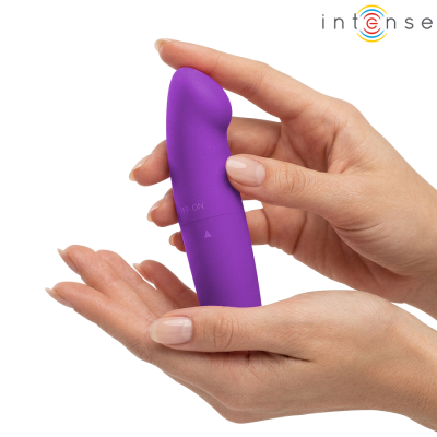Vibrador roxo em mãos femininas com unhas nude