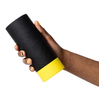 Copo térmico preto e amarelo segurado por mão com unhas pintadas em amarelo
