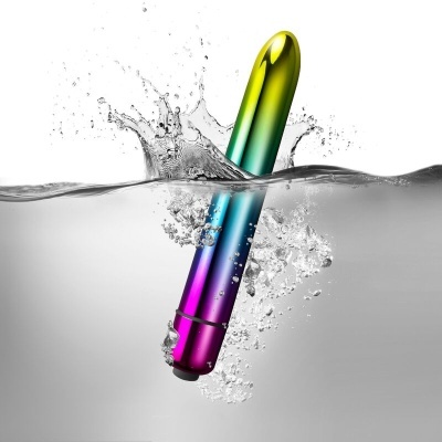 Vibrador metálico colorido submerso em água com bolhas e respingos
