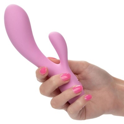 Mão com unhas rosas segurando vibrador cor-de-rosa liso