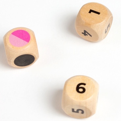 Três dados de madeira clara com números e cores sobre superfície branca