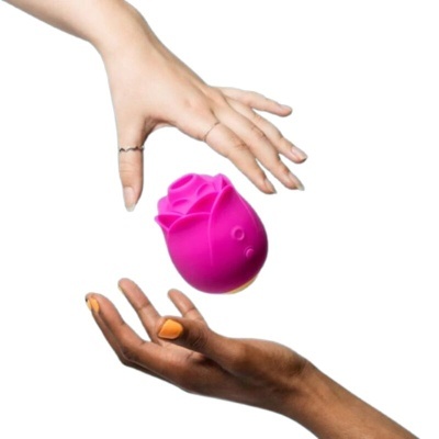 Objeto rosa em forma de rosa entre duas mãos