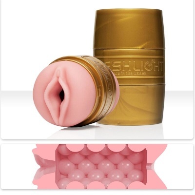 Masturbador Fleshlight dourado com interior rosa texturizado sobre fundo branco
