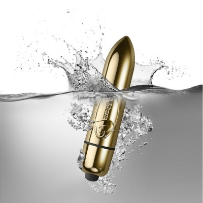 Vibrador dourado metálico submerso em água