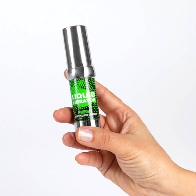 Frasco metálico com rótulo verde LIQUID VIBRATOR FRESH na mão