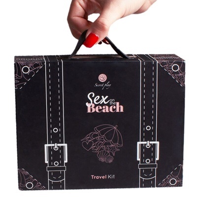 Caixa preta com o texto 'Sex on the Beach Travel Kit' e design de mala com fivelas