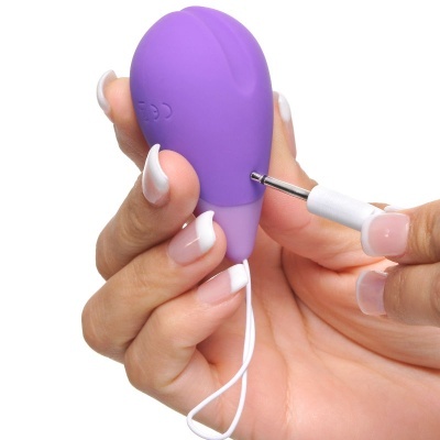 Dispositivo pequeno roxo segurado por mão com conector metálico sendo inserido
