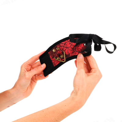 Produto em tecido preto e vermelho com padrão floral e detalhe triangular dourado nas mãos