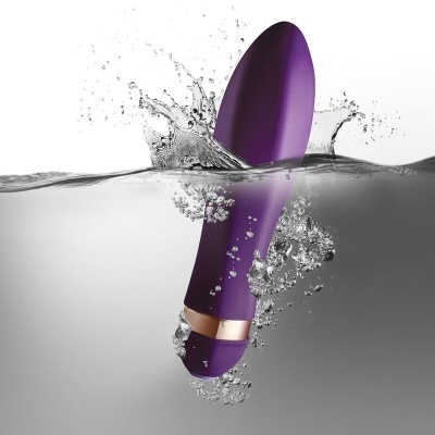 Vibrador roxo com detalhes dourados submerso em água