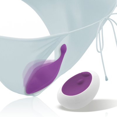 Vibrador roxo com controlo remoto branco ao lado de roupa interior branca.