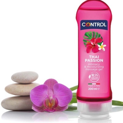 Gel de massagem Control Thai Passion rosa ao lado de orquídea rosa e pedras empilhadas
