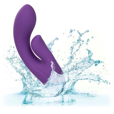 Vibrador roxo com duas extremidades imerso em água com salpicos