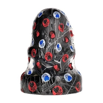 Figura negra coberta por plástico com adesivos coloridos.