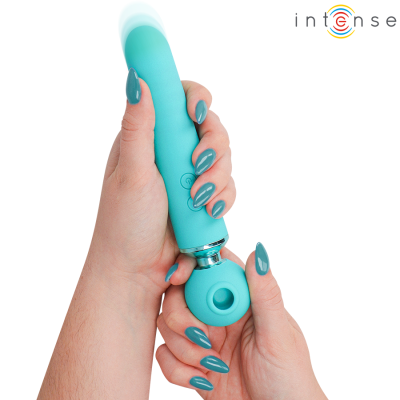 Massageador azul turquesa com cabo cilíndrico em silicone, mãos femininas segurando e unhas pintadas da mesma cor, fundo branco.