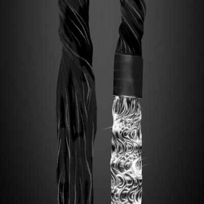 Objeto transparente ondulado com cabo preto e fundo cinzento escuro