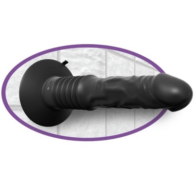 Dildo preto com ventosa numa parede de azulejos brancos
