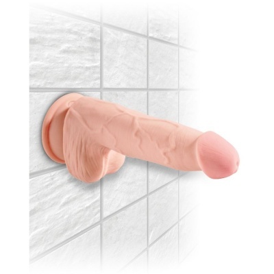Dildo cor de pele com ventosa fixado numa parede de azulejos brancos