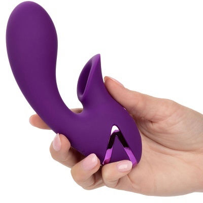 Vibrador roxo em silicone com detalhe brilhante sendo segurado por uma mão