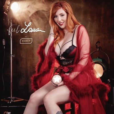 Mulher ruiva com lingerie preta e roupão vermelho, sentada, segurando objeto redondo branco