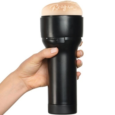 Objeto cilíndrico preto com peça de cor pele no topo com texto 'Reagan'