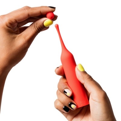 Dispositivo portátil vermelho com ponta alongada e mãos segurando com unhas coloridas