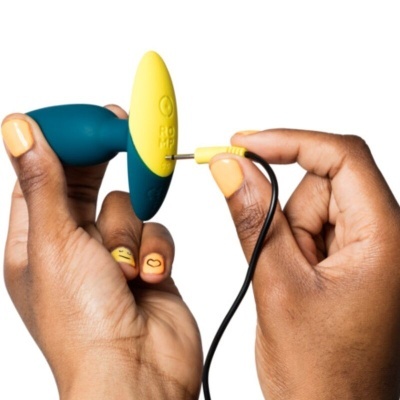 Mãos segurando dispositivo azul e amarelo com cabo preto de conexão