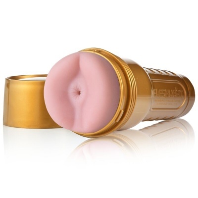 produto sexual masculino dourado com abertura em silicone cor de pele e tampa ao lado