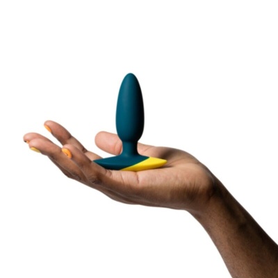 Plugue anal azul escuro com base azul e amarela na mão de um homem
