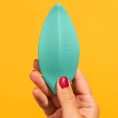 Dispositivo azul esverdeado com forma aquilina segurado por mão com unhas vermelhas